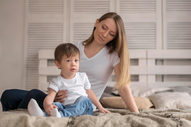 Foto madre e hijo sentados en la cama