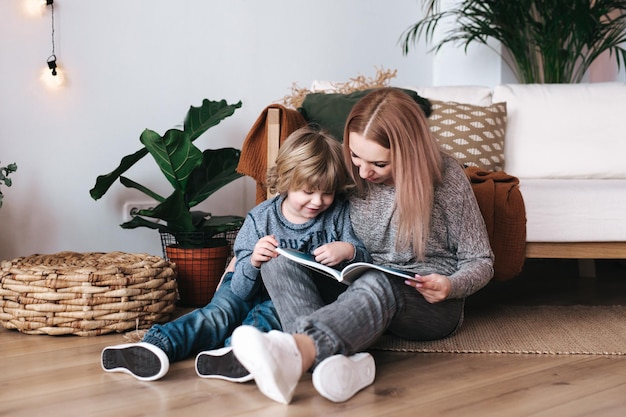 Madre e hijo sentados y leyendo libros juntos en casa