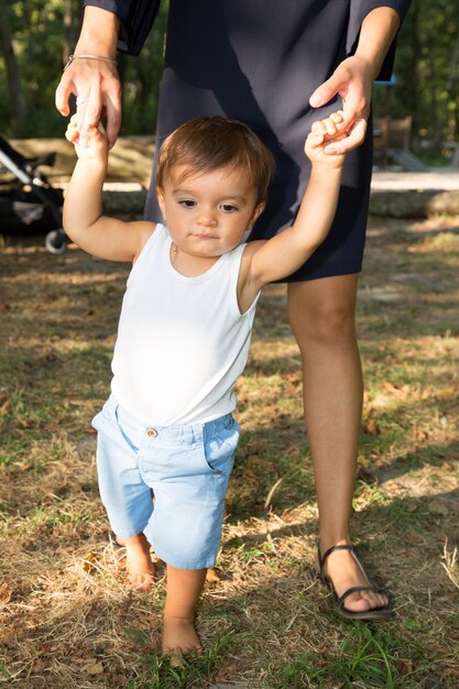 Madre e hijo tomados de la mano aprenden a caminar