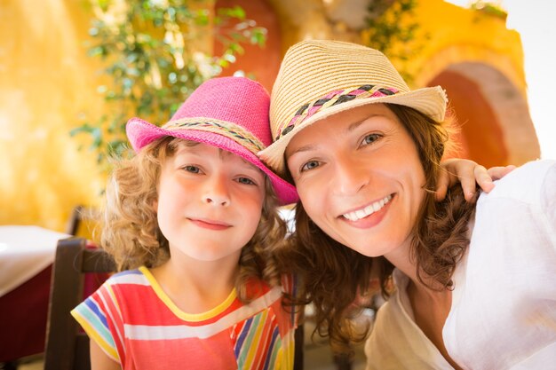 Madre e hijo tomando selfie en café de verano