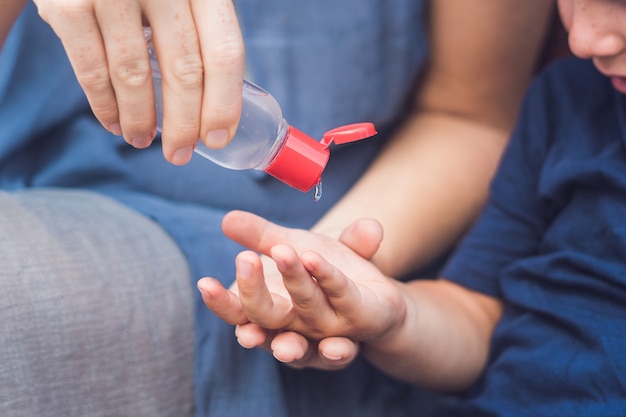 Madre e hijo usando gel desinfectante para manos.