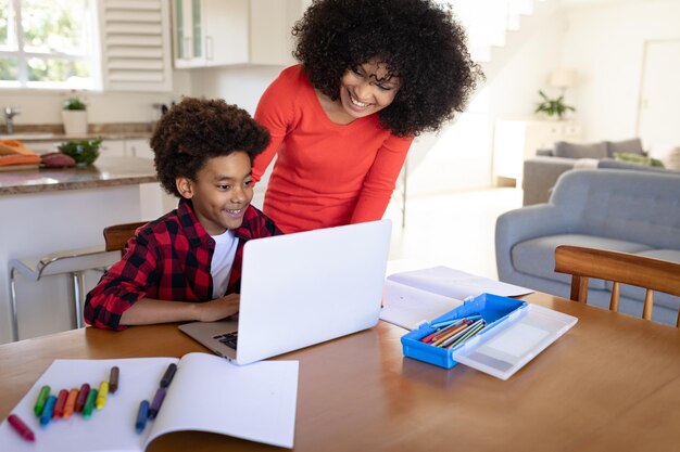 Madre e hijo usando laptop en casa