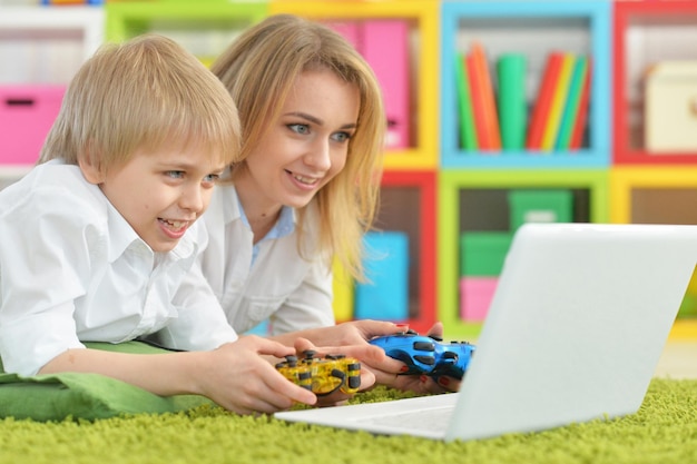 Madre e hijo usando laptop juntos jugando videojuegos