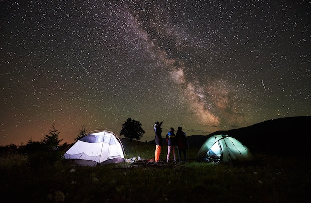 Madre e hijos acampando por la noche.