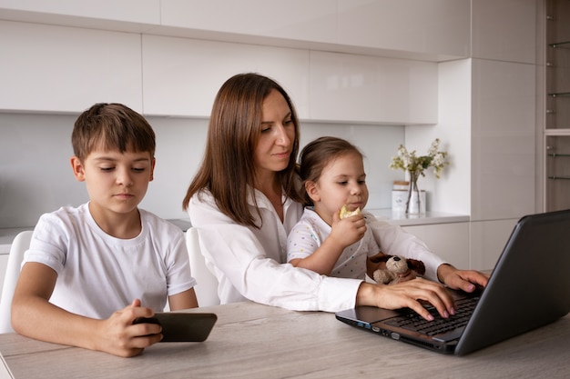 Foto madre e hijos en casa plano medio