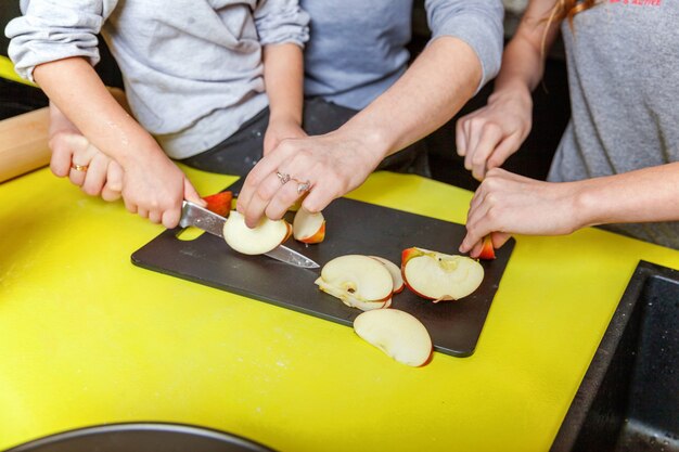 Madre e hijos cocinando en la cocina y divirtiéndose