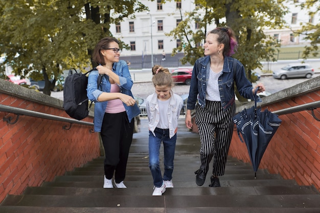 Madre e hijos dos hijas caminando por las escaleras