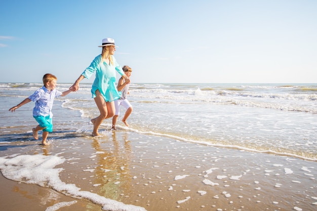 Foto madre e hijos jugando en la playa