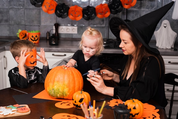 Madre e hijos tallando una calabaza