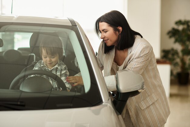 La madre elige un carro en el que le conviene llevar a su pequeño hijo.