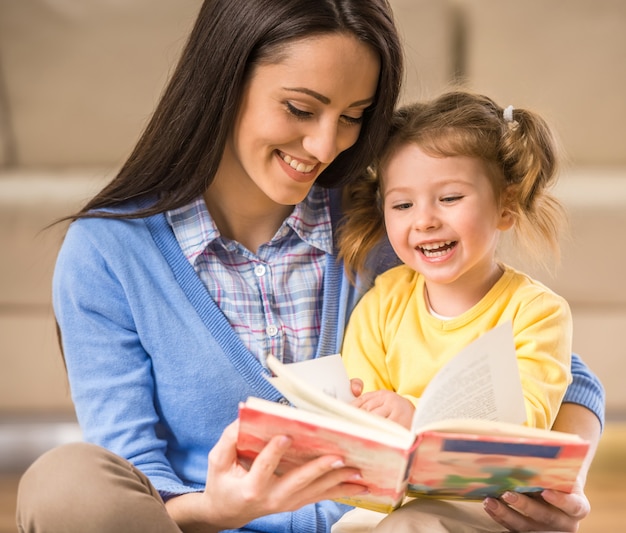 Madre encantadora está mostrando imágenes en un libro.