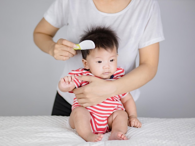 la madre está cepillando el cabello de un bebé