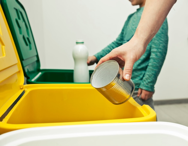 La madre le está enseñando a su hijo a clasificar la basura.