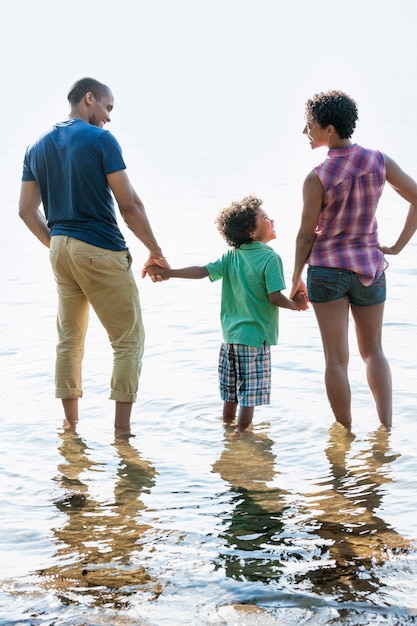 Foto una madre de familia padre e hijo jugando a orillas de un lago