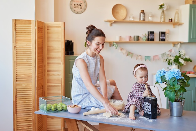 Madre de familia y su hija en la mañana desayunan en la cocina.