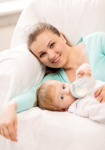 madre feliz y adorable bebé con biberón