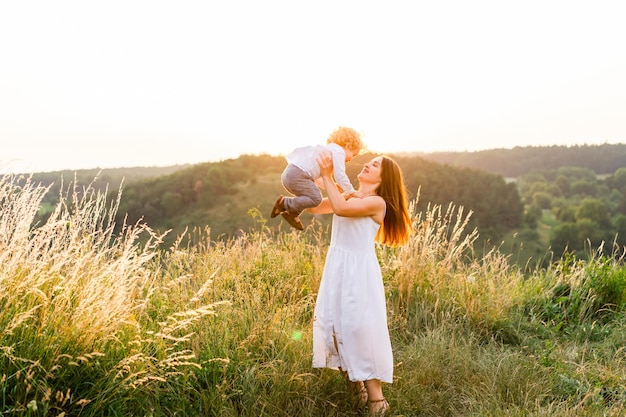 La madre feliz arroja a su hijo al campo