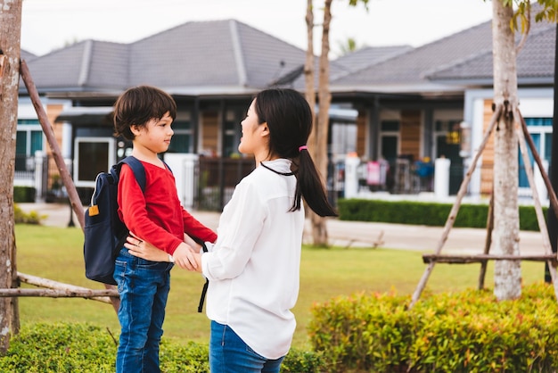 Madre feliz asiática y niño jugando al aire libre en el jardín de su pueblo