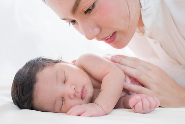 madre feliz con bebé en la cama