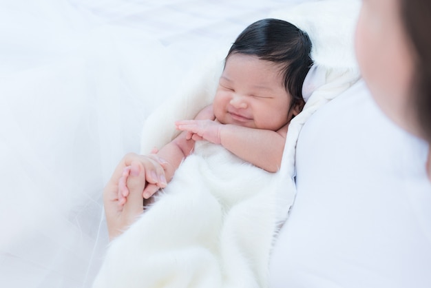 madre feliz con bebé en la cama