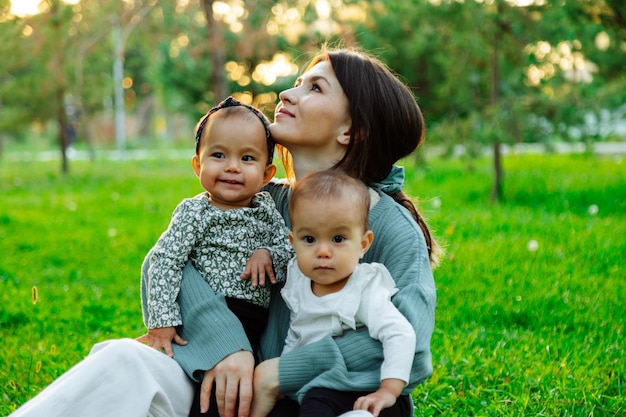 Madre feliz con bebés gemelos en el parque