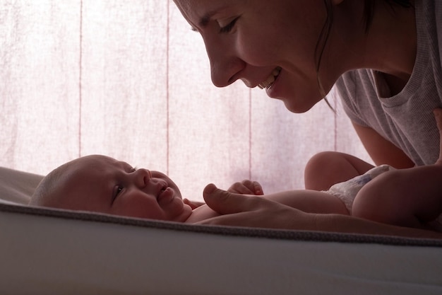 Madre feliz caucásica cambiando bebés paño limpio