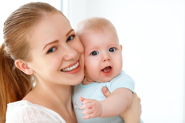 Madre feliz de la familia que juega con el bebé recién nacido