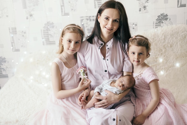 Madre feliz con hijas jóvenes y un hijo recién nacido