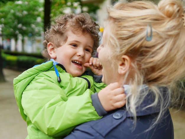 Madre feliz con hijo sonriente en sus brazos