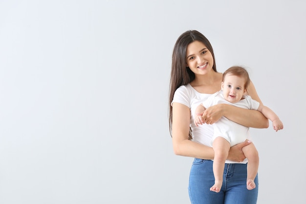 Foto madre feliz con lindo bebé en gris