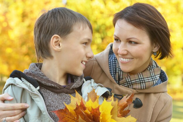 Madre feliz con niño en el parque otoño