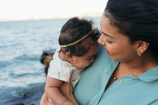 una madre feliz y su bebé en la playa