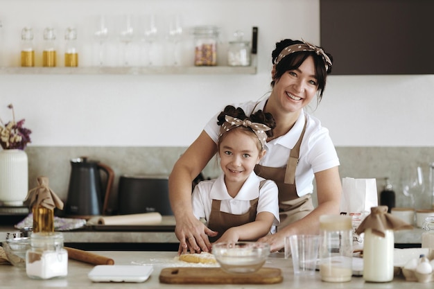 madre feliz con su niña cocinando en casa