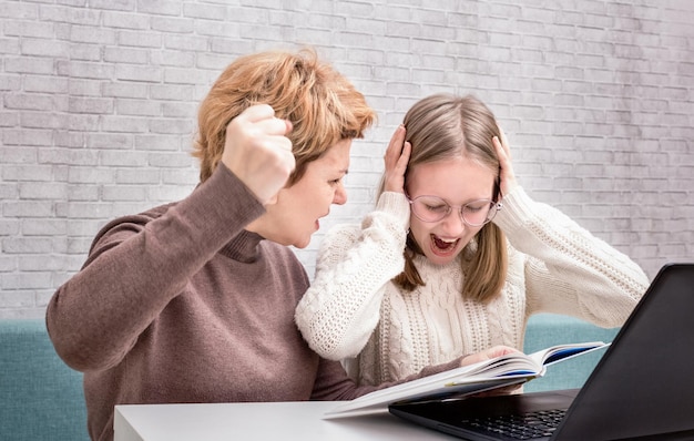 Foto madre gritando a su hija mientras hace la tarea