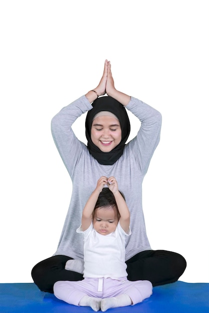 Madre haciendo ejercicios de yoga con su hija