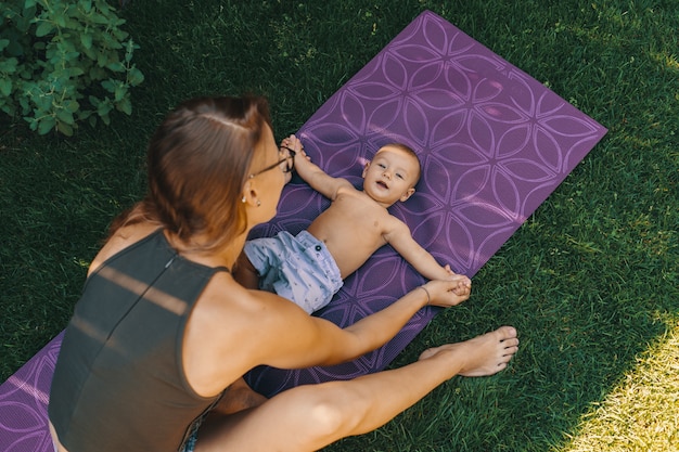 Madre haciendo yoga bebé para su hijo