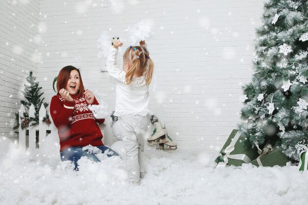 Madre con hija y arbol de navidad