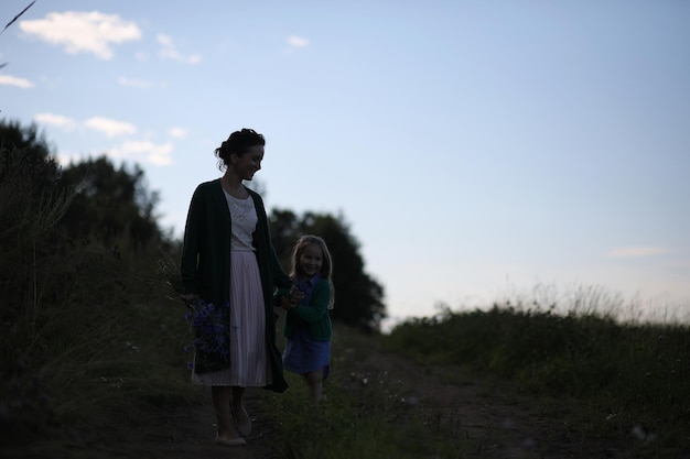 Madre con hija caminando por una carretera