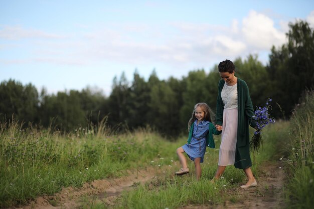 Madre con hija caminando por una carretera