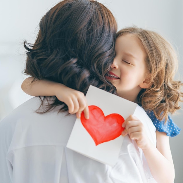 Foto una madre y una hija con un corazón en el hombro.