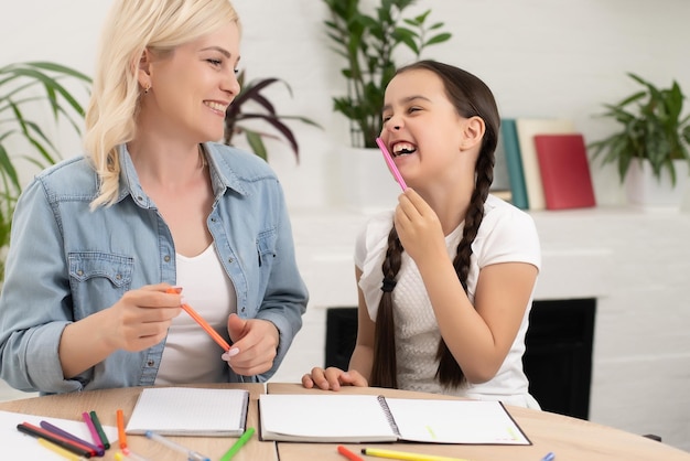 Foto madre hija estudia juntas en casa.