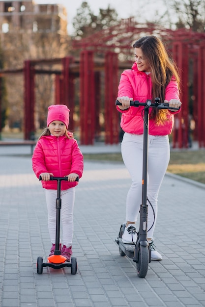 Madre con hija montando scooter eléctrico