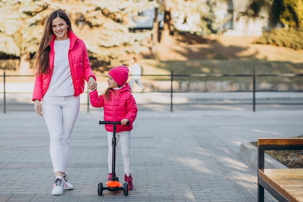 Madre con hija montando scooter eléctrico