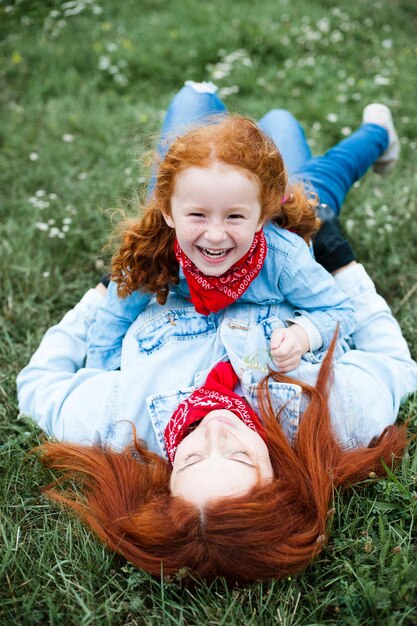 La madre y la hija pelirrojas se divierten en la naturaleza