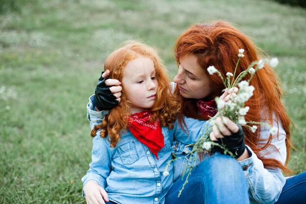 La madre y la hija pelirrojas se divierten en la naturaleza