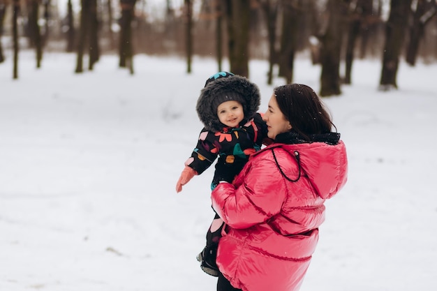 Madre con hija pequeña en un bosque de invierno