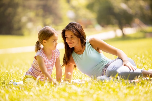 Madre con hija pequeña divirtiéndose en el parque en un día soleado