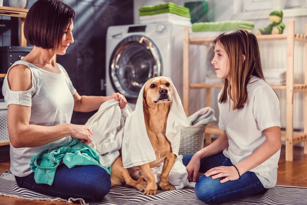 Madre, hija y perro divirtiéndose en el lavadero