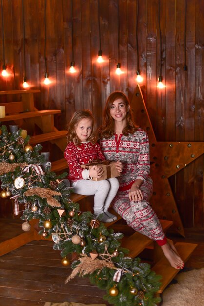 La madre y la hija sentadas en los escalones cerca de Navidad