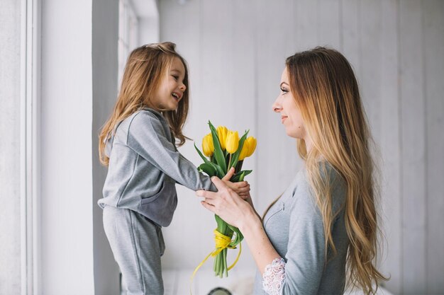 Foto una madre y una hija sosteniendo flores en un baño